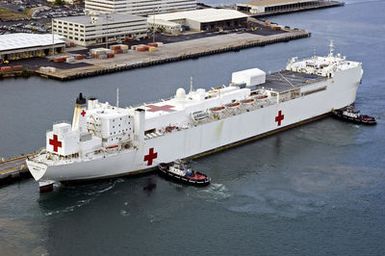 The U.S. Navy Military Sealift Command Hospital Ship, the USNS MERCY (T-AH 19) enters Pearl Harbor, HI., as tugboats assists for a brief port visit. The USNS MERCY (T-AH 19) which operated off the coast of Dili, East Timor provided humanitarian assistance to local residents. Sept. 20, 2006. (U.S. Navy photo by CHIEF Mass Communication SPECIALIST 1ST Class Dennis Cantrell) (Released)