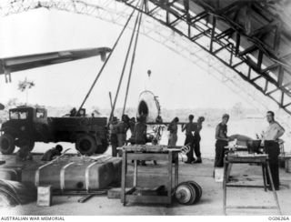 KIRIWINA, TROBRIAND ISLANDS, PAPUA. 1944-01-31. INSIDE THE HANGAR OF NO. 12 REPAIR AND SALVAGE UNIT RAAF, BEHIND THE BATTLE LINE, WHERE A SPITFIRE AIRCRAFT OF NO. 79 SQUADRON RAAF IS BEING REPAIRED