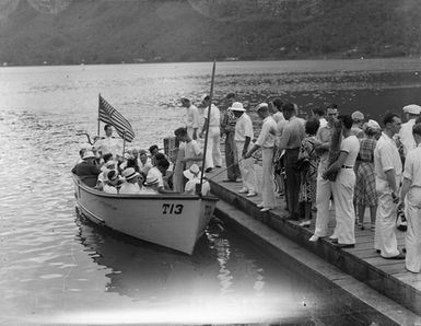 [View of many people on a boat with an American flag]