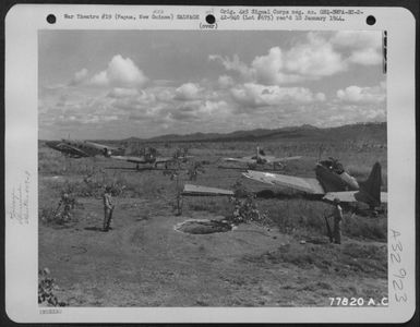 Pvt. William V. Bernbaum, of Brooklyn, N.Y. and Pfc. Alvin Vanartsdalen of Philadephia, Pa., both of the 409th Service Squadron, 8th Service Group, standing guard over an American plane boneyard near Port Moresby, Papua, New Guinea. 2 November (U.S. Air Force Number 77820AC)