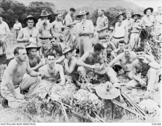 PAPUA. 1942-08. TROOPS OF THE 2/27TH AUSTRALIAN INFANTRY BATTALION EATING A MEAL IN THE OPEN AT THE SPOT IN THE HIKINUMU DISTRICT WHERE THEY BIVOUACED FOR THE NIGHT