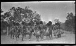 Motu men in circle, drumming and dancing near a dubu platform