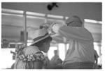 Man placing hat on woman's head