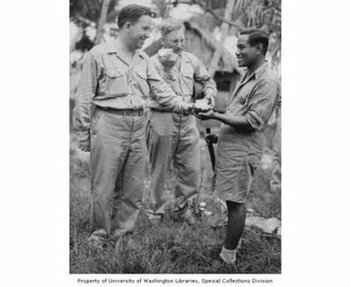 Congressmen Henry M. Jackson and Ellis E. Patterson eating coconut with a Hawaiian man during a visit to Pearl Harbor, Hawaii, July 18, 1945