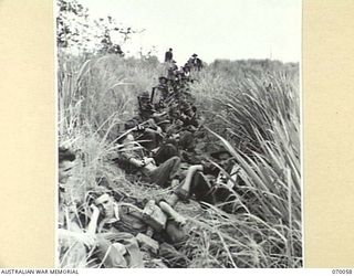 SIO, WEST NEW GUINEA. 1944-01-24. "D" COMPANY 4TH INFANTRY BATTALION, RESTING ALONG THE SIDES OF THE TRACK AT SIO. IDENTIFIED PERSONNEL ARE: N447439 PRIVATE C.N. BATTERSON (1); N427220 PRIVATE M.A. ..
