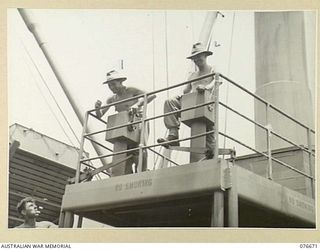 JACQUINOT BAY, NEW BRITAIN. 1944-11-04. VX77222 SAPPER W. MITCHELL (1) AND NX97602 SAPPER A. GLOVER (2) OF THE 33RD DOCKS OPERATING COMPANY, OPERATING THE ELECTRIC WINCHES ABOARD THE TROOPSHIP ..