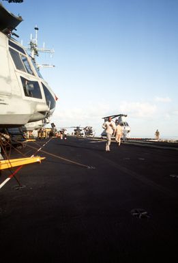 Members of the 22nd Marine Expeditionary Unit run on the flight deck of the amphibious assault ship USS GUAM (LPH-9) during morning physical training (PT)