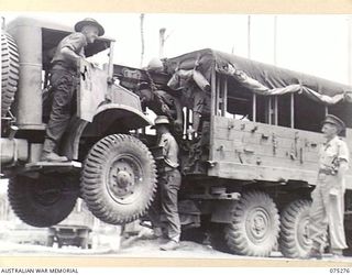 MADANG, NEW GUINEA. 1944-08-15. PERSONNEL OF THE 165TH GENERAL TRANSPORT COMPANY USING A 6 X 6 RECOVERY WAGGON TO LIFT AND TOW A BROKEN DOWN 4 X 4 CHEVROLET TRUCK. IDENTIFIED PERSONNEL ARE:- ..