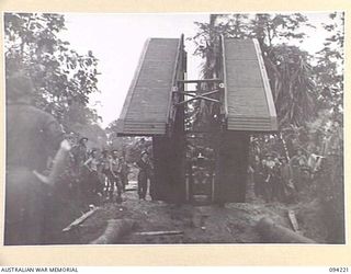 SOUTH BOUGAINVILLE. 1945-07-20. A CONVENANTER BRIDGE BUILDING TANK OF 2/4 ARMOURED REGIMENT, LAYING A 32-FOOT SPAN OVER A ROAD WASH-AWAY BETWEEN THE OGORATA AND MOBIAI RIVERS TO ALLOW URGENTLY ..