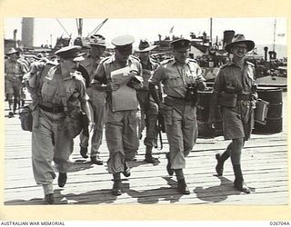 PORT MORESBY, PAPUA. 1942-09. BRIGADIER K. EATHER, COMMANDING 25TH AUSTRALIAN INFANTRY BRIGADE AND STAFF OFFICERS ON THE WHARF AT PORT MORESBY AFTER DISEMBARKATION OF THE 25TH BRIGADE