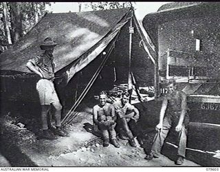 ORO BAY, NEW GUINEA. 1943-04. THE ORIGINAL TRANSPORT OFFICE AT THE MEDICAL DRESSING STATION, 10TH FIELD AMBULANCE. LEFT TO RIGHT: VX108076 LIEUTENANT L. B. STUART; LANCE CORPORAL R. MCKIM; SERGEANT ..