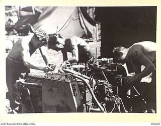 JACQUINOT BAY, NEW BRITAIN. 1945-09-01. CRADFTSMEN OF 2/4 ARMOURED REGIMENT WORKSHOP CARRYING OUT REPAIRS TO AN ENGINE SALVAGED FROM A TANK KNOCKED OUT BY JAPANESE MINE. THE MEN ARE CRAFTSMAN S.G. ..