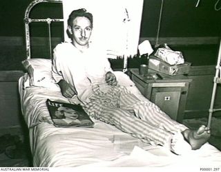 NEW BRITAIN, 1945-09. RELEASED POW RESTING HIS LEG IN BED AT THE AUSTRALIAN 2/8TH GENERAL HOSPITAL. (RNZAF OFFICIAL PHOTOGRAPH.)