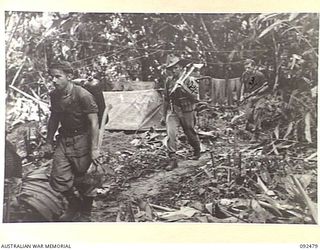 BOUGAINVILLE. 1945-05-20. TROOPS CARRYING PORTABLE FLAME THROWERS MOVING ALONG THE TRACK TO A COMPANY, 24 INFANTRY BATTALION, DURING THE BATTALION'S OUTFLANKING MOVE AROUND JAPANESE FORCES ALONG ..