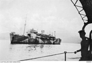 1945-09. RABAUL HARBOUR. PORT SIDE VIEW OF THE LANDING SHIP INFANTRY (LARGE) HMAS KANIMBLA. LANDING CRAFT VEHICLE PERSONNEL ARE CARRIED IN DAVITS ALONG HER SIDE. THE SHIP'S PREVIOUS ALL OVER DARK ..