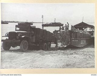 CAPE WOM, NEW GUINEA, 1945-05-29. A LOADED TRUCK LEAVING AN AUSTRALIAN BARGE AT THE BEACH HEAD. SUPPLIES ARE THEN TRANSPORTED TO THE FIELD MAINTENANCE CENTRE DUMPS