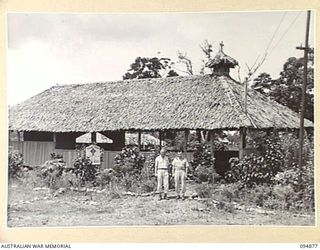 LAE AREA, NEW GUINEA. 1945-08-11. COLONEL I.J. WOOD, COMMANDING OFFICER, 2/7 GENERAL HOSPITAL (1) AND CHAPLAIN W.J. FAHY (2), OUTSIDE THE ROMAN CATHOLIC CHAPEL AT THE HOSPITAL