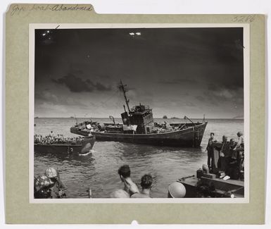 Photograph of Coast Guard-manned Landing Craft Sweeping Past an Abandoned Japanese Boat