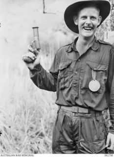 KUBA LAKE, RAMU VALLEY, NEW GUINEA. 1943-12-25. VX14097 CAPTAIN G. O'DAY, OFFICIAL STARTER AT THE CHRISTMAS CARNIVAL AND REGATTA ORGANISED BY MEMBERS OF THE 2/14TH INFANTRY BATTALION, 7TH DIVISION