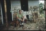 Father Laughman in a chair in front of his house