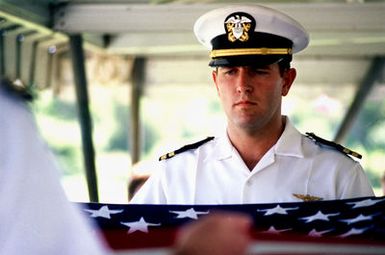 An officer folds the flag at Lieutenant Junior Grade (LTJG) Richard C. Sather's funeral at the National Memorial Cemetery of the Pacific. Salter was buried with full military honors after his body was returned from Vietnam after 21 years. He was one of the first American pilots killed there in 1964