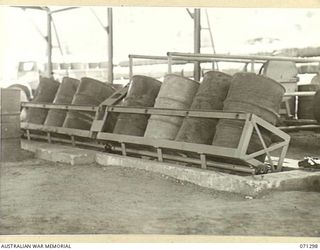 PORT MORESBY, PAPUA, 1944-03-21. OIL DRUMS ON THE MACHINE AT THE END RUMBLING PLANT, UNDER OPERATION IN SHEDS AT THE 1ST BULK PETROLEUM STORAGE COMPANY, (NEW GUINEA FORCE)