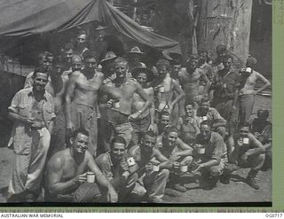NADZAB, NEW GUINEA. C. 1944-02. AN INFORMAL GROUP PORTRAIT OF BARE-CHESTED SAWMILL WORKERS OF NO. 62 MOBILE WORKS SQUADRON RAAF, HAVING AFTERNOON TEA