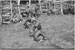 Women with digging sticks clean grounds of the government rest house in Tsembaga