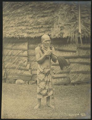 [Elderly man standing in front of house]