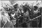 Pig festival, pig sacrifice, Tsembaga: in center, man displays shell valuables for trade, others in crowd also carry items for exchange