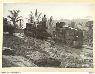 JACQUINOT BAY, NEW BRITAIN. 1944-11-05. TROOPS OF THE 6TH INFANTRY BRIGADE USING A TRACTOR AND SLED TO TRANSPORT THEIR STORES AND EQUIPMENT FROM THE BEACH TO THE UNIT CAMP