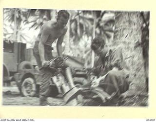 MILILAT, NEW GUINEA. 1944. MECHANICS OF THE 231ST LIGHT AID DETACHMENT ATTACHED TO THE HEADQUARTERS, 5TH DIVISION, RECONDITIONING AN "EVINRUDE", 5HP. OUTBOARD MOTOR (MADE IN THE U.S.A.O WHICH WAS ..