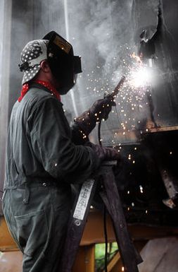 A worker uses an electric arc welder on the fuselage of a B-52D aircraft, one of three that are being scrapped in accordance with the SALT II treaty between the United States and the Soviet Union