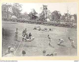 HERBERTON, QLD. 1945-01-19. SAPPER N J CAMPBELL, 2/7 FIELD COMPANY, ROYAL AUSTRALIAN ENGINEERS, REPRESENTING DIVISION TROOPS, B GROUP, (1), WINNING THE 50 YARDS SACK RACE FROM PRIVATE GEARY, 2/3 ..