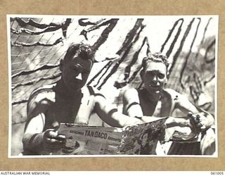 DONADABU AREA, NEW GUINEA. 1943-12-01. GUNNER OF NO. 3 GUN. A TROOP, NO. 7 BATTERY 2/4TH AUSTRALIAN FIELD REGIMENT TAKING THINGS EASY DURING A LULL INK THE SHOOTING AT THE COMBINED EXERCISE WITH ..