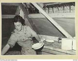 LAE, NEW GUINEA, 1945-05-06. LIEUTENANT-COLONEL M.J. SPENCER, ASSISTANT CONTROLLER OF AUSTRALIAN WOMEN'S ARMY SERVICE, WASHING MEDICAL EQUIPMENT IN THE REGIMENTAL AID POST, AUSTRALIAN WOMEN'S ARMY ..