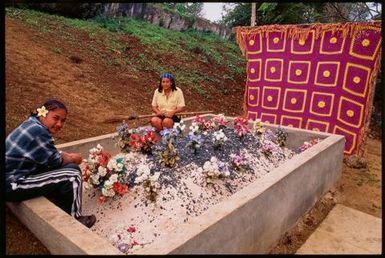 Two young women sitting on a grave,Tonga