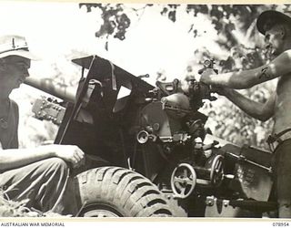 KALILUP, NEW BRITAIN. 1945-02-07. VX75417 GUNNER G.G. PHILIP (1) AND SX15018 GUNNER J.J. HYNES (2) 2/14TH FIELD REGIMENT, TESTING AND ADJUSTING THE SIGHTS OF ONE OF THE UNIT 25 POUNDERS DURING A ..