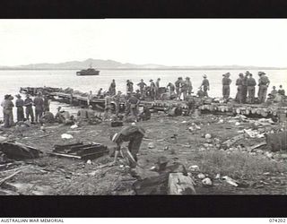 HANSA BAY, NEW GUINEA. 1944-06-22. TROOPS OF C COMPANY, 4TH INFANTRY BATTALION WAITING AT THE JETTY FOR THE LANDING BARGES TO TAKE THEM ON THE NEXT PHASE OF THEIR ADVANCE AGAINST THE JAPANESE ..