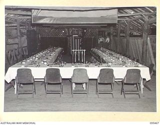 LAE AREA, NEW GUINEA, 1945-08-25. THE LAY-OUT OF TABLES IN THE OFFICERS' MESS, 4 ADVANCED ORDNANCE DEPOT, AUSTRALIAN ARMY ORDNANCE CORPS BEFORE THE VICTORY DINNER HELD FOR ALL ORDNANCE OFFICERS IN ..