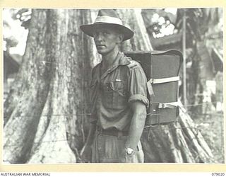 BOUGAINVILLE ISLAND. 1945-02-12. VX39063 CAPTAIN R.H.L. DUNN, 2/8TH FIELD AMBULANCE DEMONSTRATING A NEW TYPE OF AMBULANCE PACK WHICH IS BEING TESTED IN THE AREA