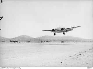 With flaps fully lowered, a RAAF Mark 1 Lockheed Hudson aircraft lands at a Port Moresby aerodrome after completing its bombing mission over Lae and Salamaua. Note that the Hudson is fitted with ..