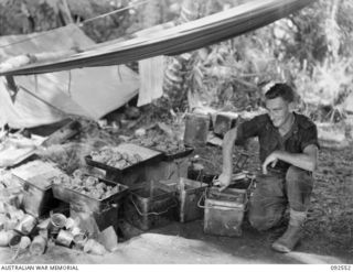 BOUGAINVILLE. 1945-05-24. PRIVATE L.J. LENNARD, D COMPANY, 26 INFANTRY BATTALION (AUSTRALIAN IMPERIAL FORCE), PREPARES LUNCH FOR THE COMPANY IN THE COOKHOUSE