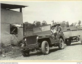 LAE BASE AREA, NEW GUINEA. 1944-12-27. MEMBERS OF THE 3RD CORPS PROVOST COMPANY CHECKING IN AT THE CONTROL POST AT THE ENTRANCE TO THE 3RD CORPS SALVAGE UNIT. IDENTIFIED PERSONNEL ARE:- VX134589 ..