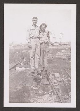 [Two Servicemen Standing at Water Well]