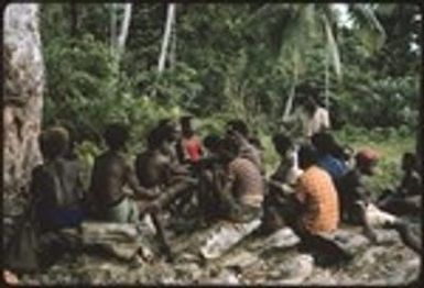 Men sitting on rocks for some kind of meeting, and shots of the surrounding gardens