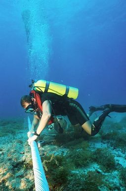 CHIEF Equipment Operator (EOC) Robert Duran places cable wraps on a section of damaged underwater cable at the Pacific Missile Range Facility off Kauai, Hawaii.(Exact date unknown)