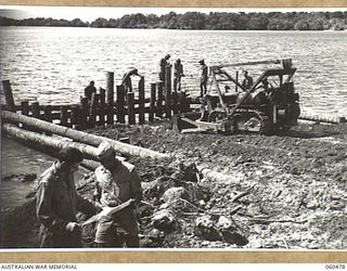 FINSCHHAFEN AREA, NEW GUINEA. 1943-11-11. LIEUTENANT B. K. LLOYD OF DENVER, COLORADO, USA, (1) AND SERGEANT A. DUNGY OF MICHIGAN, USA, (2) BOTH OF THE 870TH UNITED STATES ENGINEER AVIATION ..