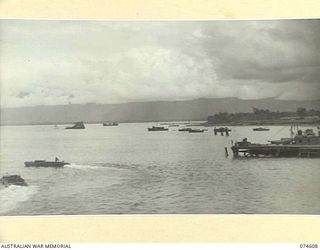 LAE AREA, NEW GUINEA. 1944-07-06. A SECTION OF THE HARBOUR SHOWING A LARGE JAPANESE SHIP DOWN BY THE STERN IN THE LEFT CENTRE