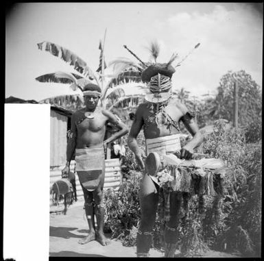 Two decorated dancers with one wearing a mask and both holding fringed hand drums, Sepik River, New Guinea, 1935, 2 / Sarah Chinnery